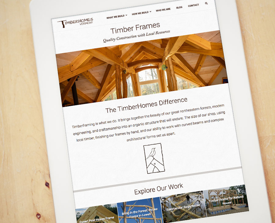 iPad on wood surface showing website for Vermont timber frame company